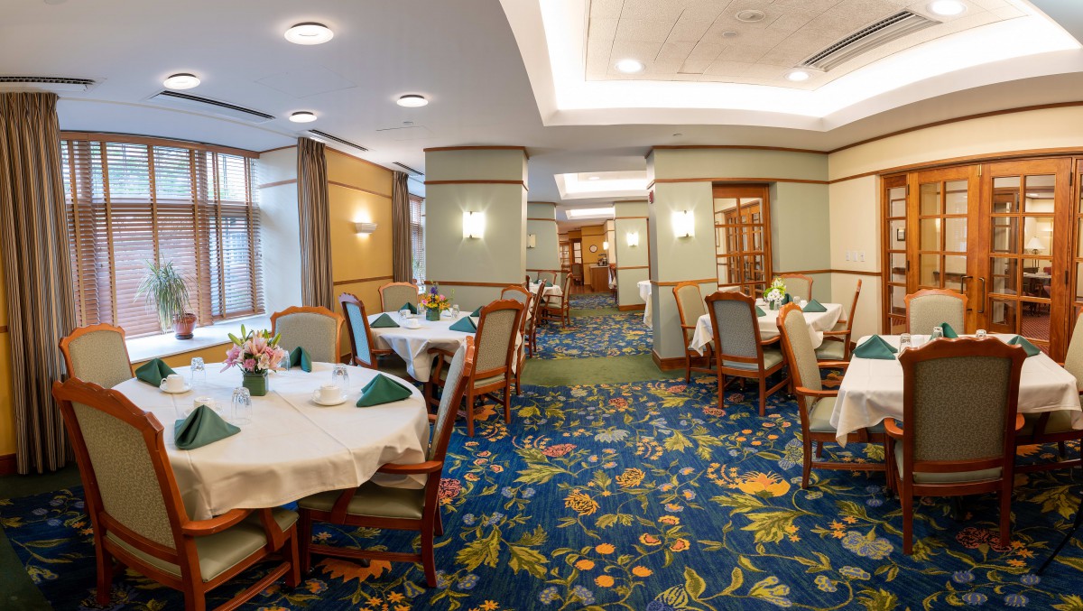 A spacious and elegantly decorated restaurant dining area with neatly arranged tables and chairs.