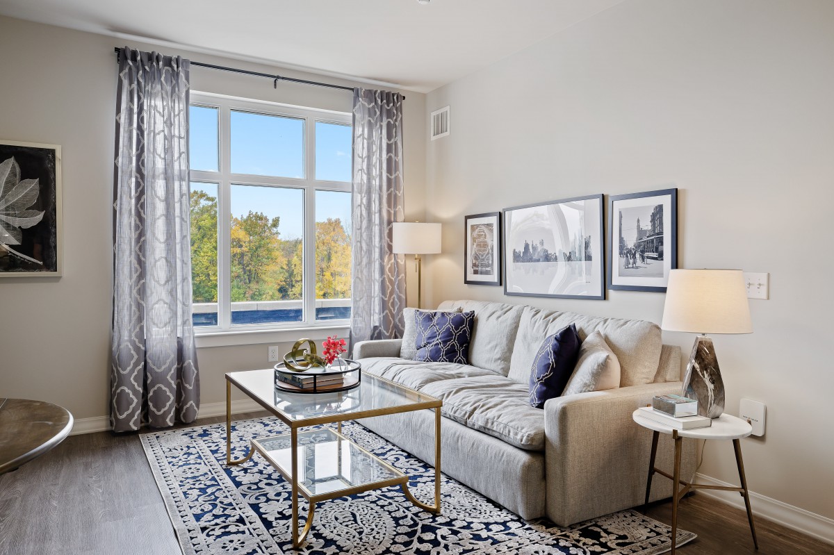 A beautifully decorated living room with a comfortable sofa, stylish coffee table, and ample natural light from the large window.