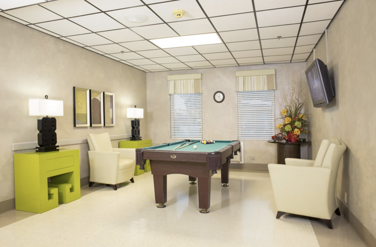 A modern game room featuring a pool table and comfortable seating.