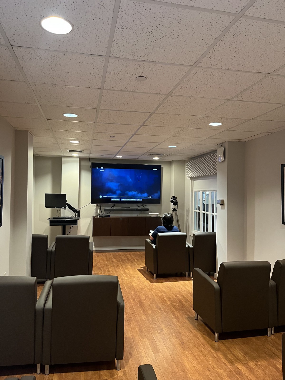 A comfortable lounge area with a large television and seating, designed for meetings or presentations.