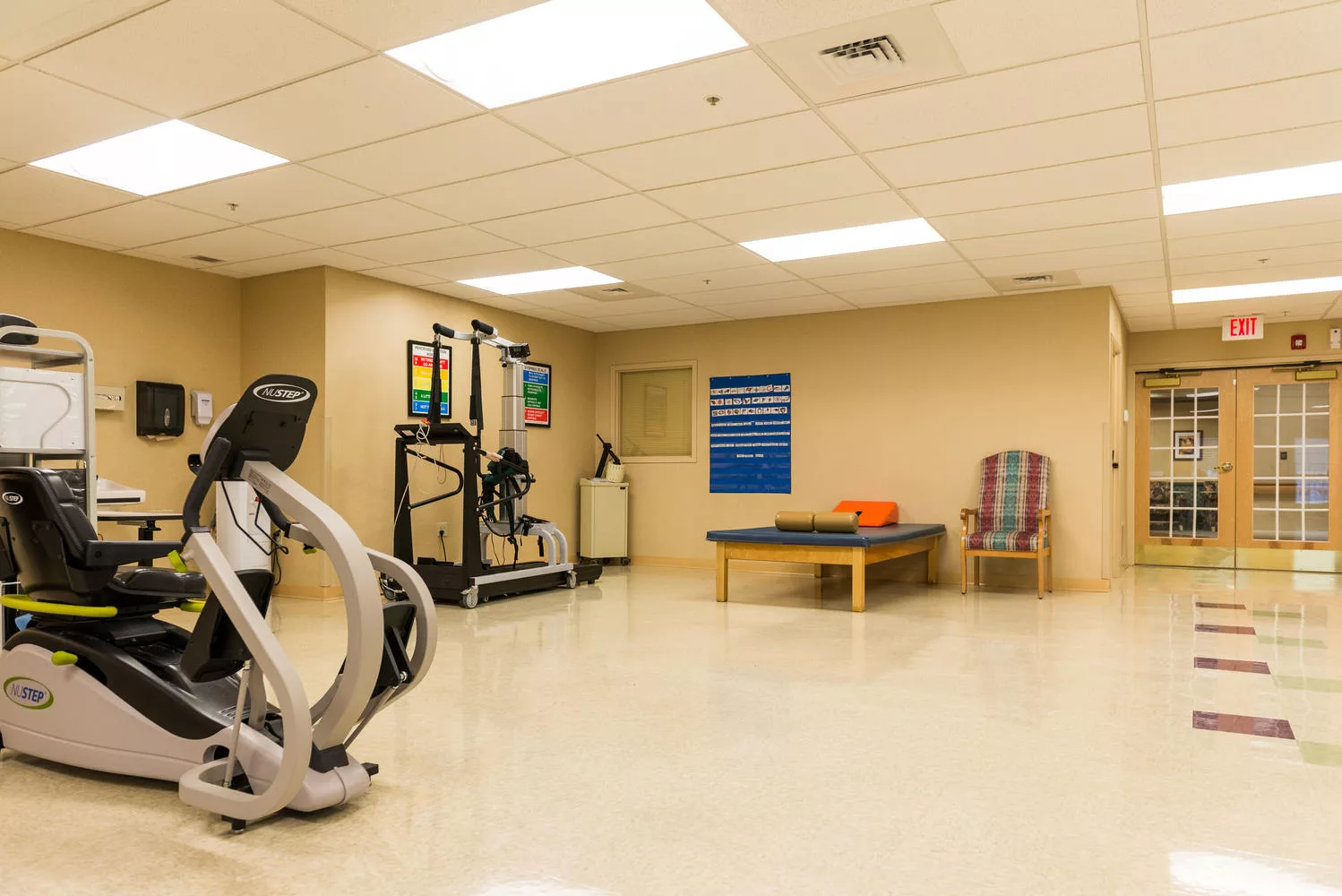 A rehabilitation or fitness room with exercise equipment and therapy table.