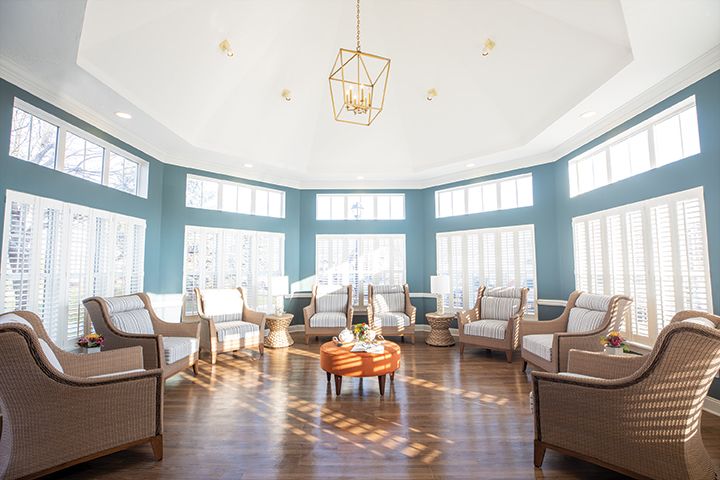 A bright and airy sunroom with ample seating and large windows.