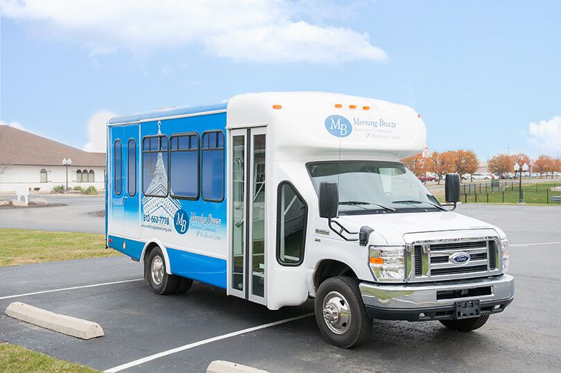 A blue and white shuttle bus parked in a parking lot.