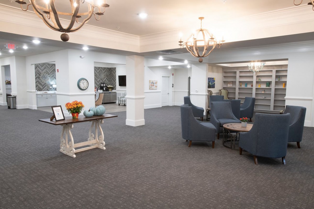 A spacious and elegantly decorated lounge area with comfortable seating and chandeliers.