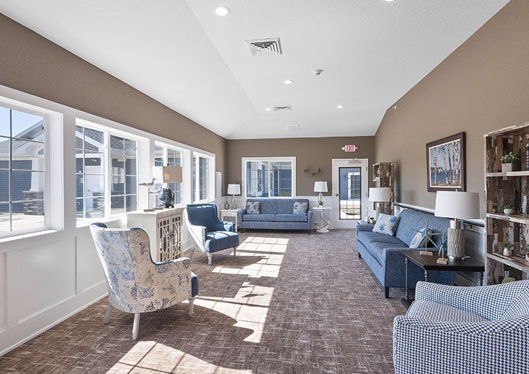 A spacious living room with elegant furniture and large windows allowing natural light to brighten the space.