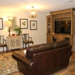 A cozy living room with a leather sofa, entertainment center, and elegant decor.