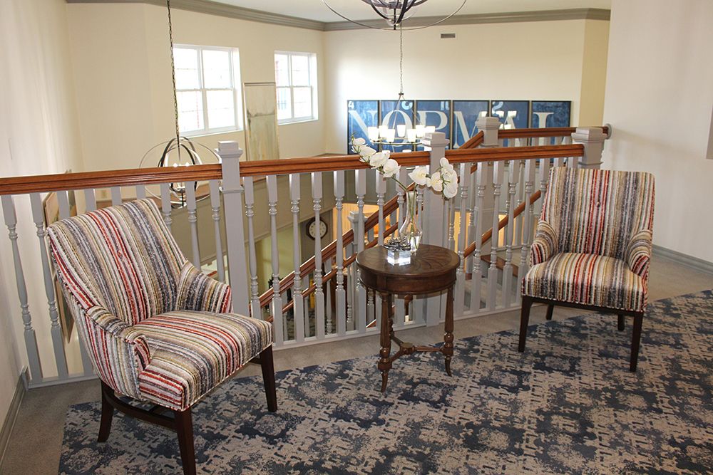 A cozy sitting area with striped chairs and a small table in a well-decorated interior space.