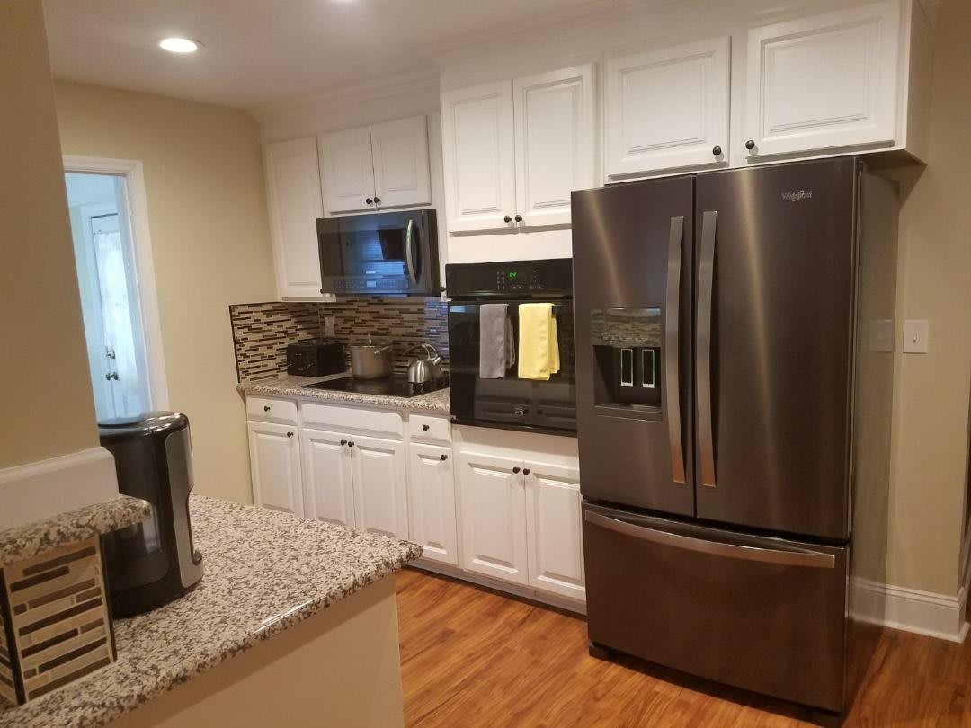 Modern kitchen with stainless steel appliances and white cabinetry.
