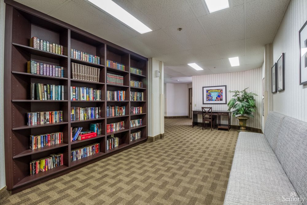 A quiet hallway with a bookshelf filled with books and a small seating area.