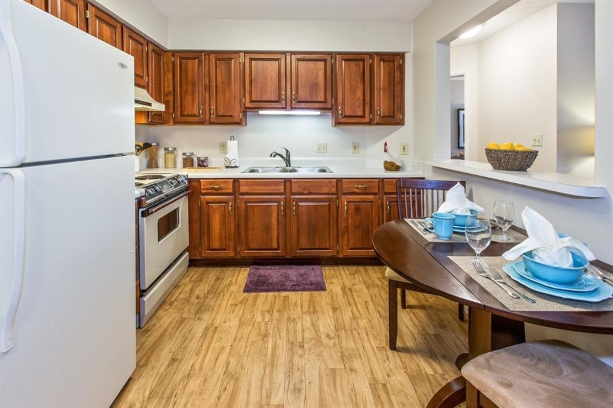 A cozy kitchen with wooden cabinets and a small dining area.