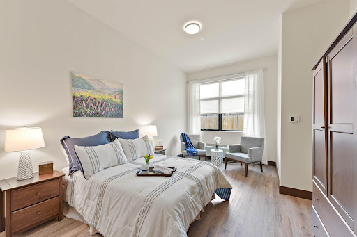 A cozy bedroom featuring modern furniture and ample natural light.