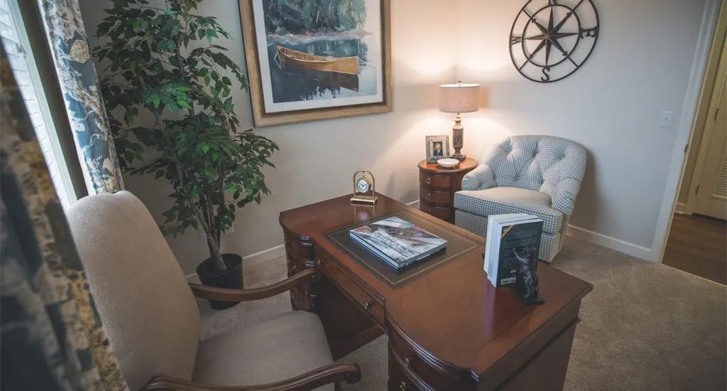 Cozy office space with a wooden desk, comfortable chairs, and decorative elements.