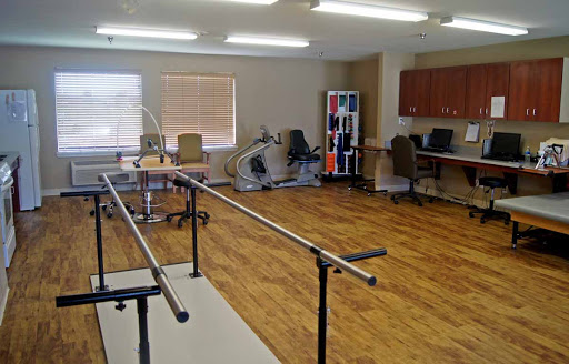 A spacious therapy room equipped with rehabilitation tools and exercise bars.