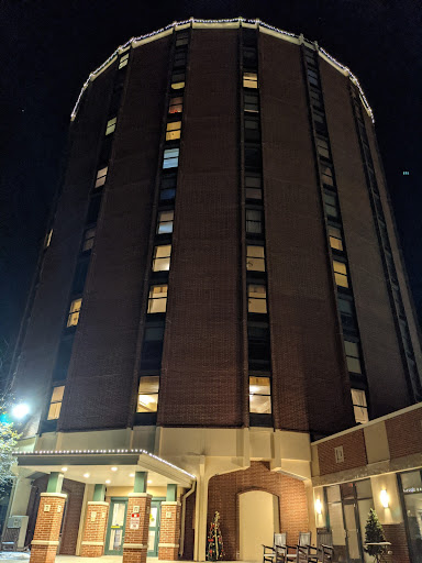 A tall hotel building illuminated at night.