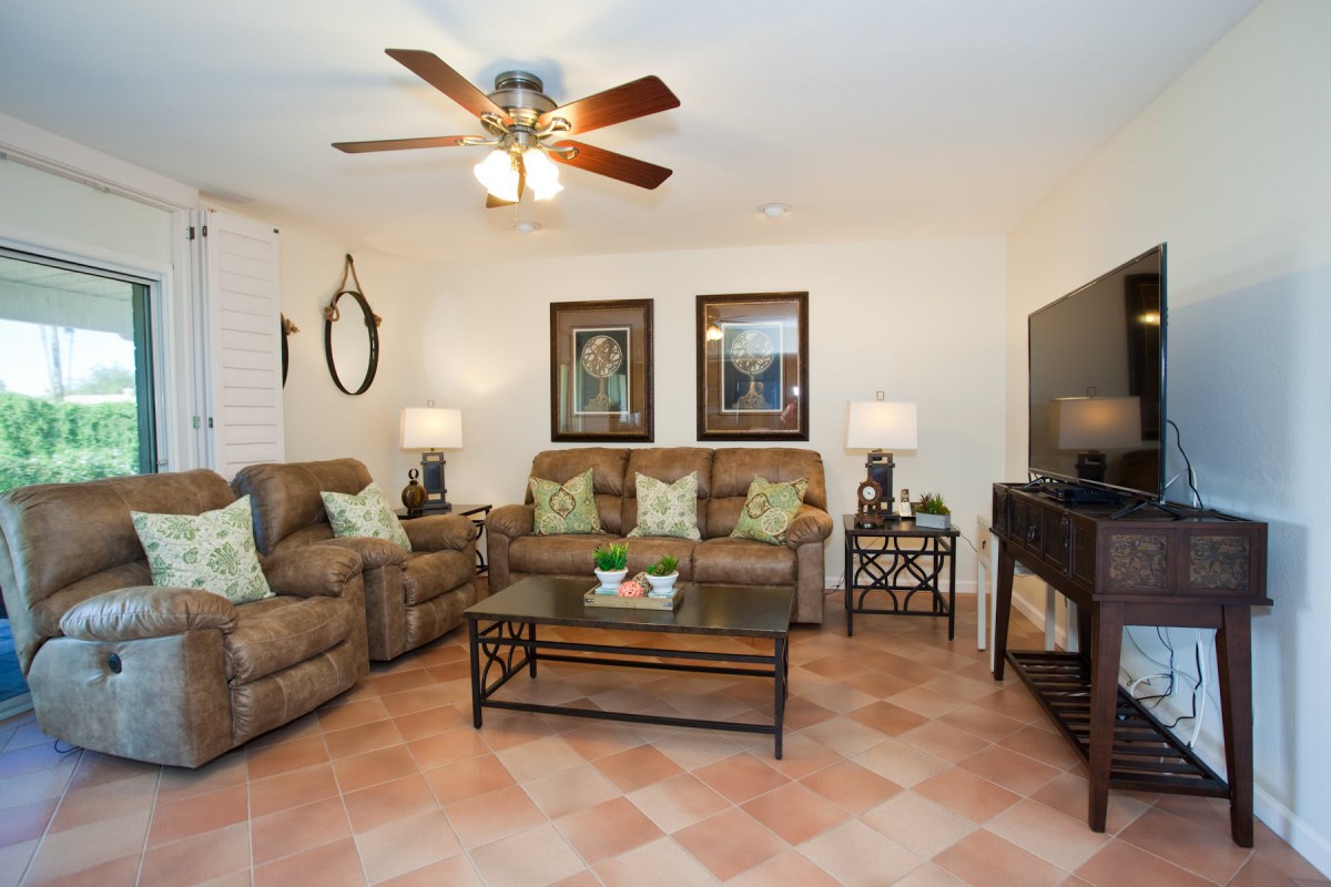 A cozy living room with sofas, armchairs, and decorative elements.