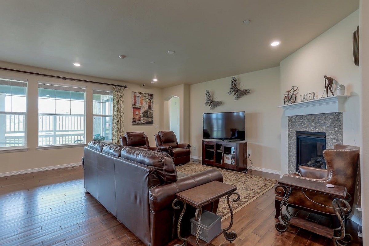 A cozy living room with leather sofas, a television, and a fireplace.