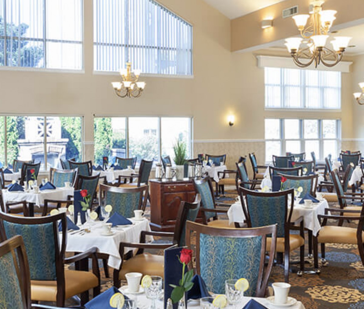 An elegant dining room with neatly arranged tables and chairs, set for service.