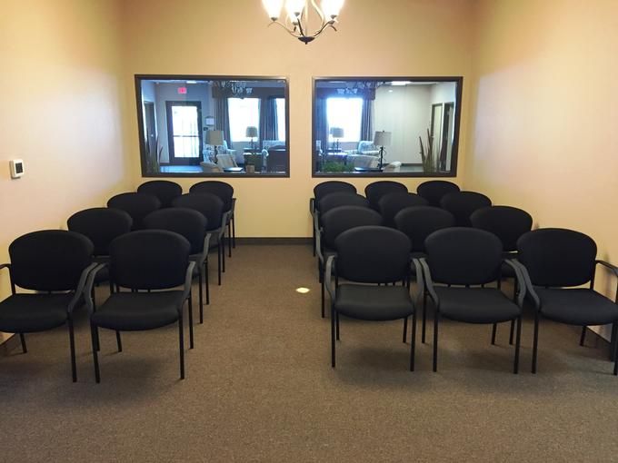 A neatly arranged waiting area with rows of black chairs in an office setting.