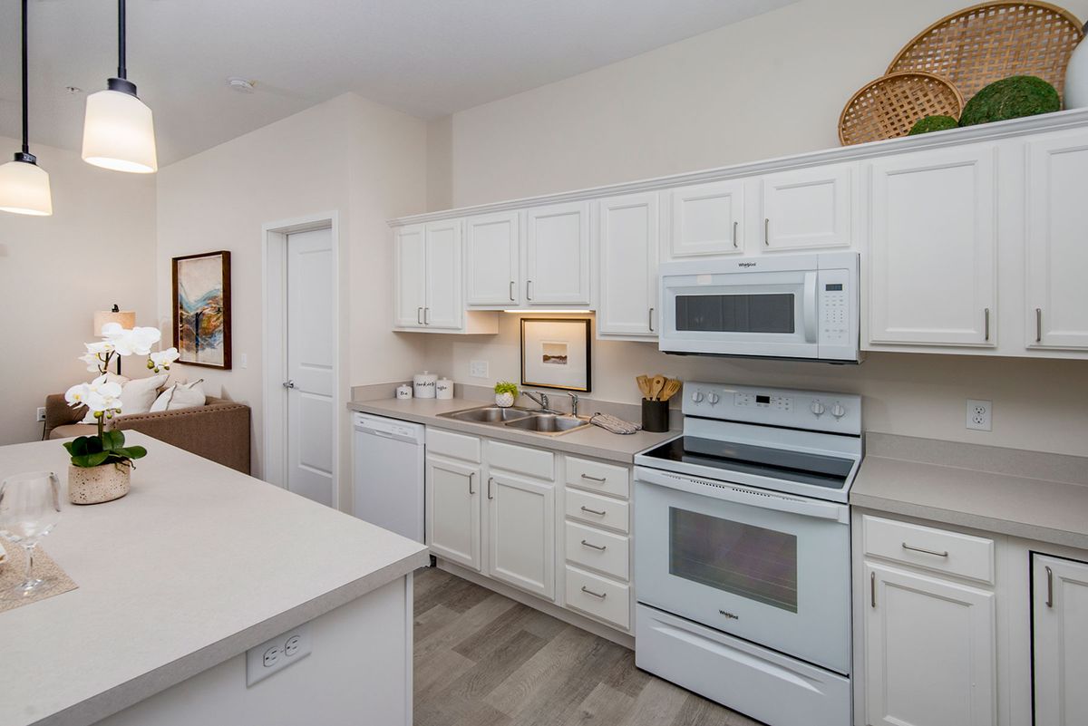 A modern kitchen with white cabinets and built-in appliances.