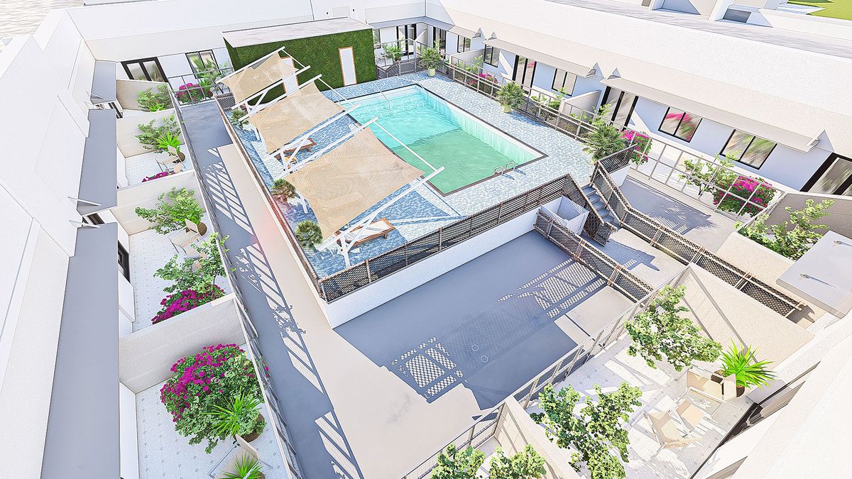 A modern rooftop pool area with sun loungers in a luxury apartment complex.