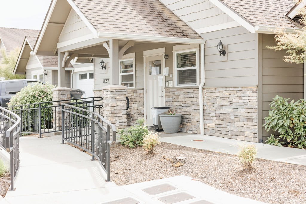A welcoming front entrance of a house with a stone facade and ramp access.
