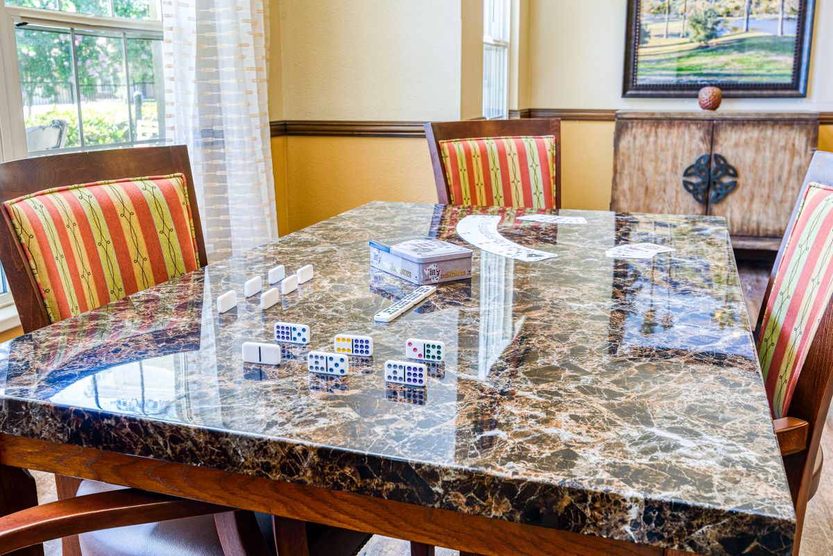 A dining room with a marble table and striped chairs.
