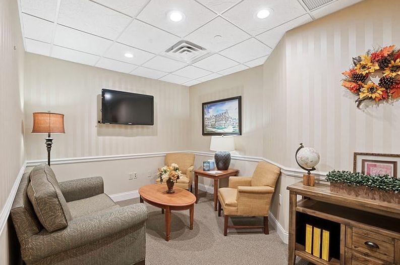 A cozy waiting room with comfortable seating, a TV, and decorative elements.