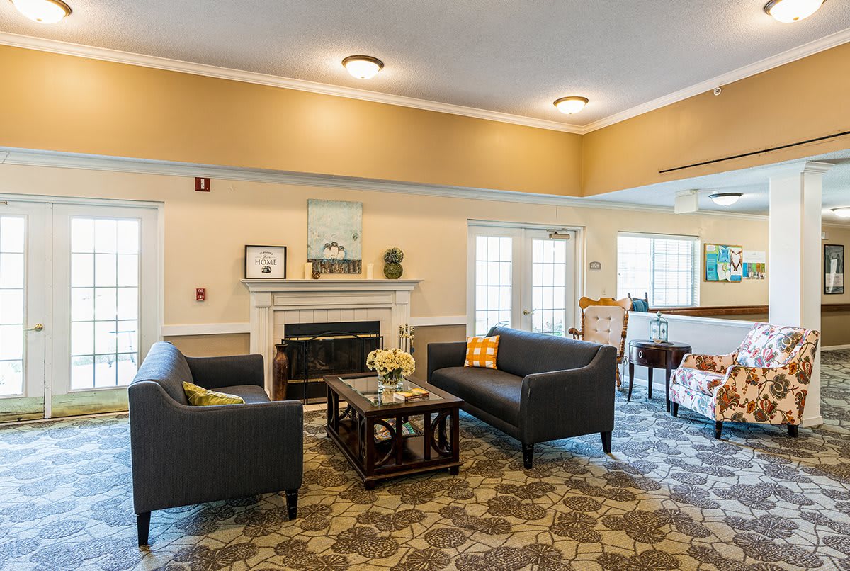 A cozy living room with matching sofas, a central coffee table, and a decorative fireplace.