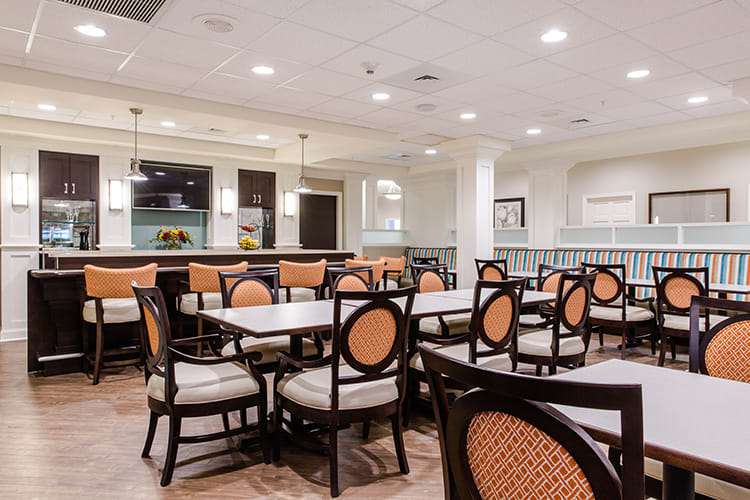 An empty dining hall with neatly arranged tables and chairs.