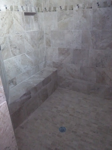 A modern shower space featuring marble tiles, showcasing a simple and elegant design.