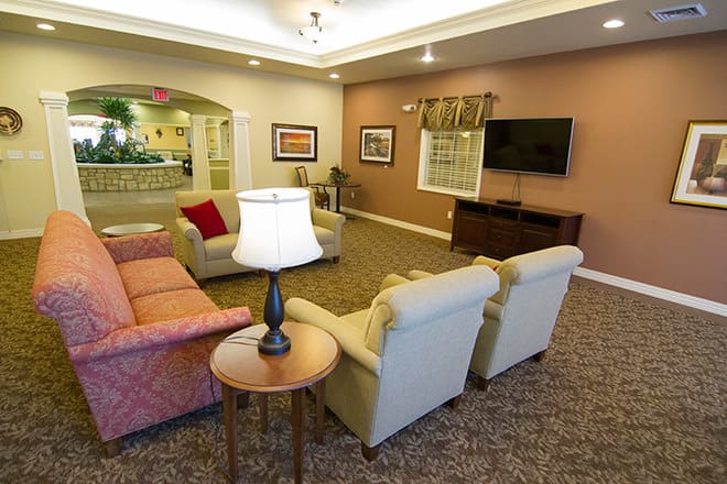 A cozy living room with a sofa, armchairs, and a television.