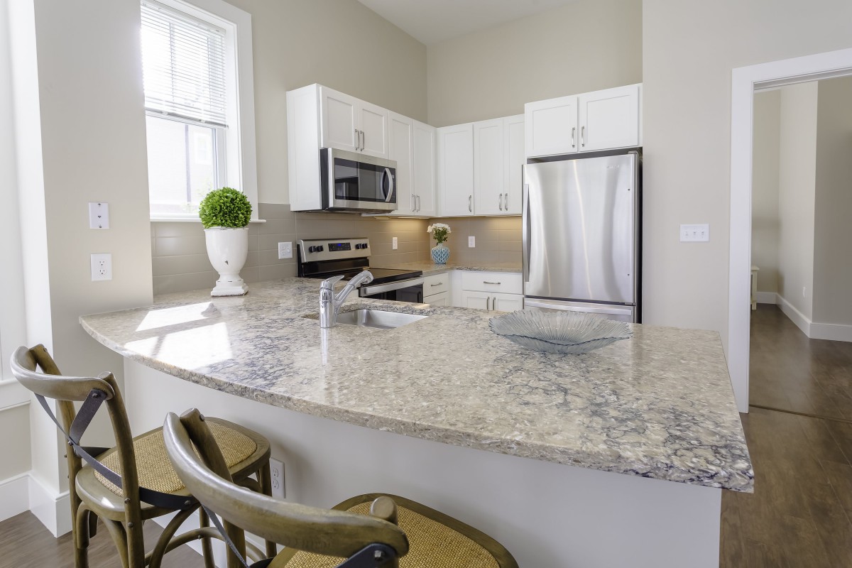 A modern kitchen with granite countertops and stainless steel appliances.
