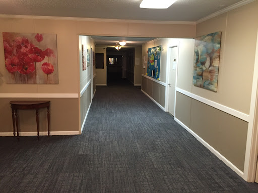 A view of a well-lit hallway adorned with colorful artwork.