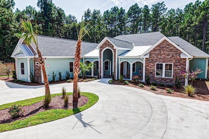 A suburban house with a circular driveway and landscaped yard.