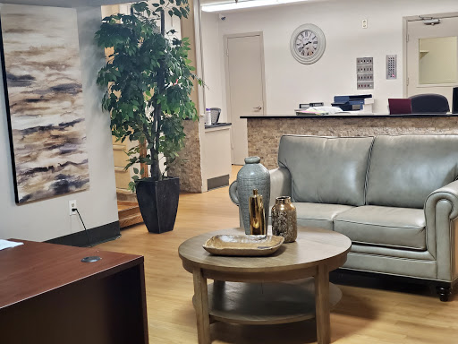 A cozy waiting area featuring modern furniture and decorative elements, perfect for an office environment.