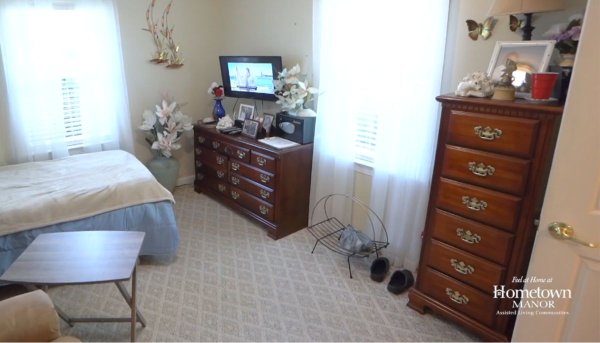 A cozy bedroom with a dresser, television, and decorative elements.