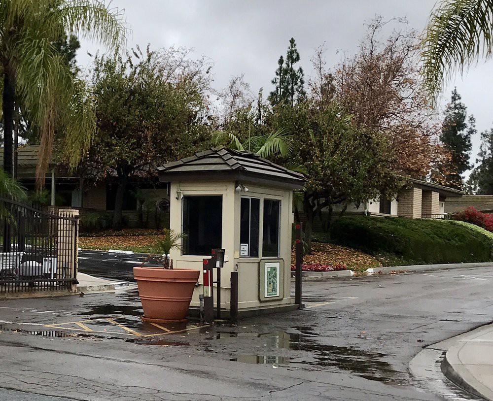 A small guard booth at the entrance of a gated community on a cloudy day.