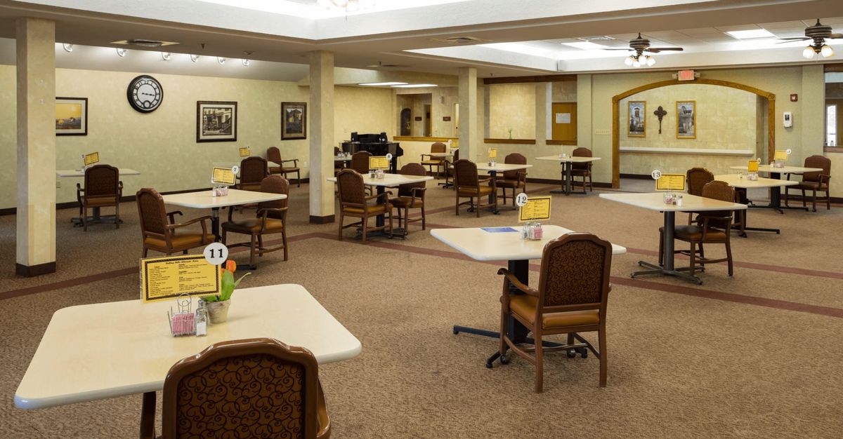 An empty dining room with neatly arranged tables and chairs.