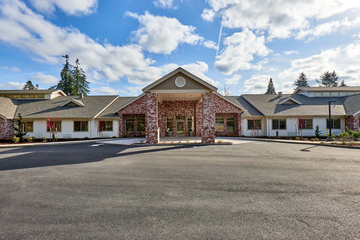 A brick building with a large entrance and a clear sky above.