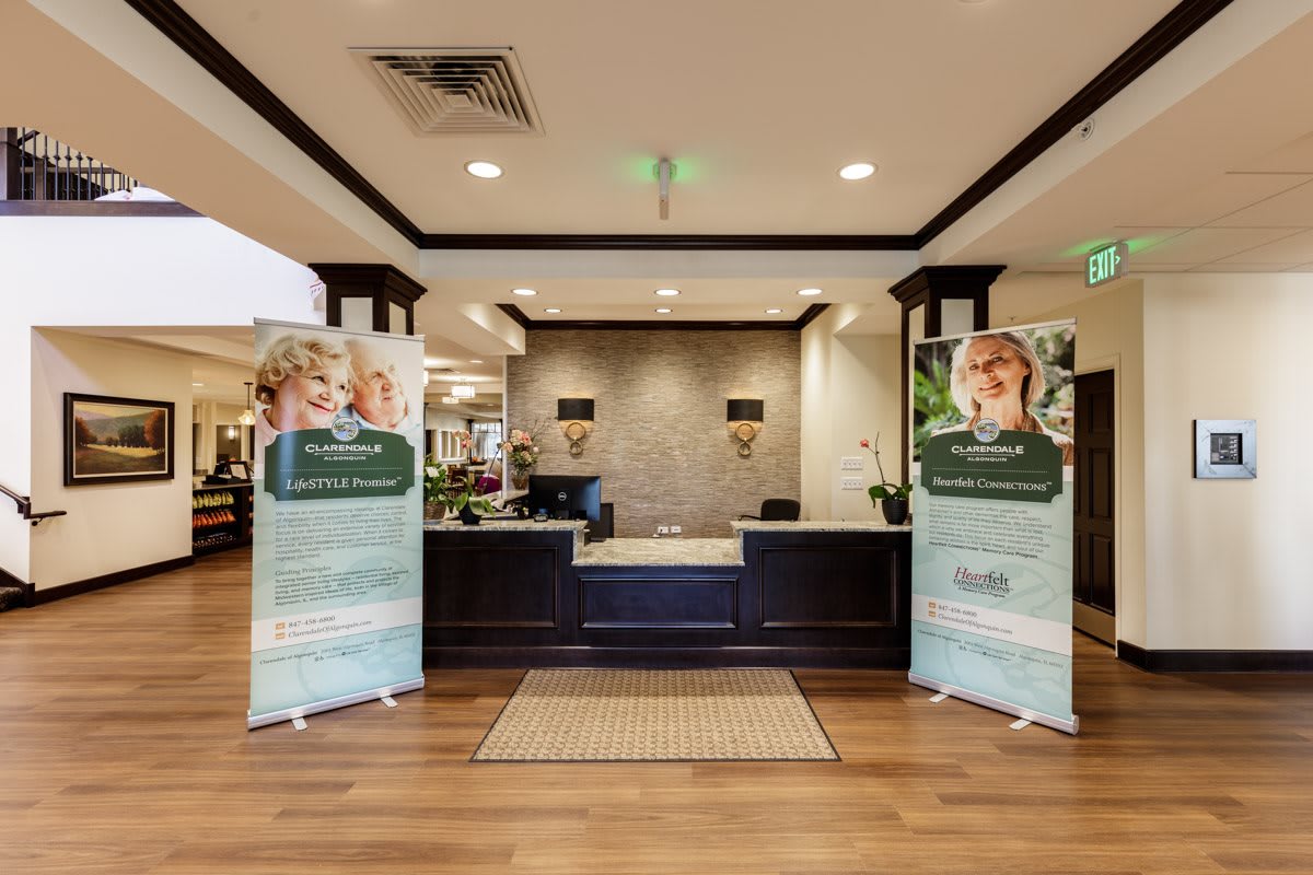 A modern lobby with a reception desk and two promotional banners.