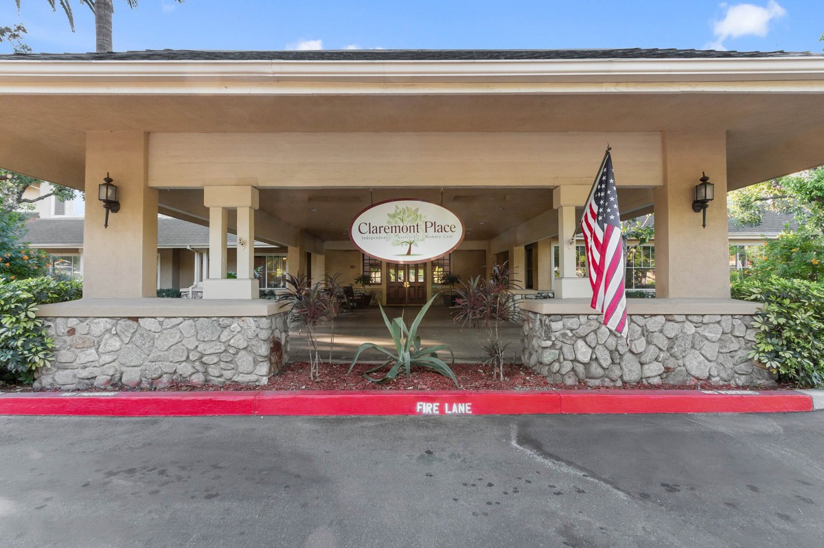 The entrance to a building with a sign and an American flag displayed.