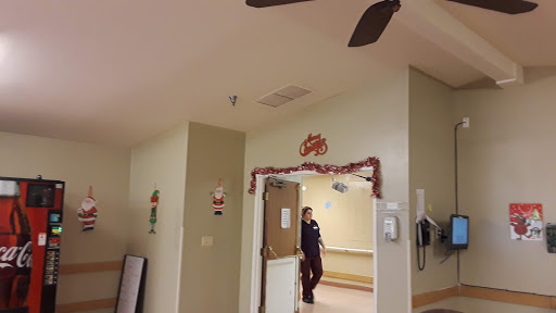 A view of an interior hallway with a doorway and ceiling fan.