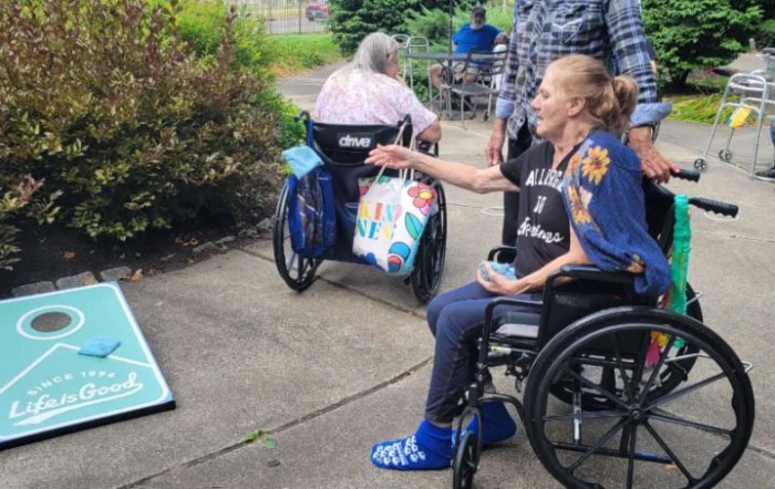 Elderly individuals in wheelchairs enjoying an outdoor game together.