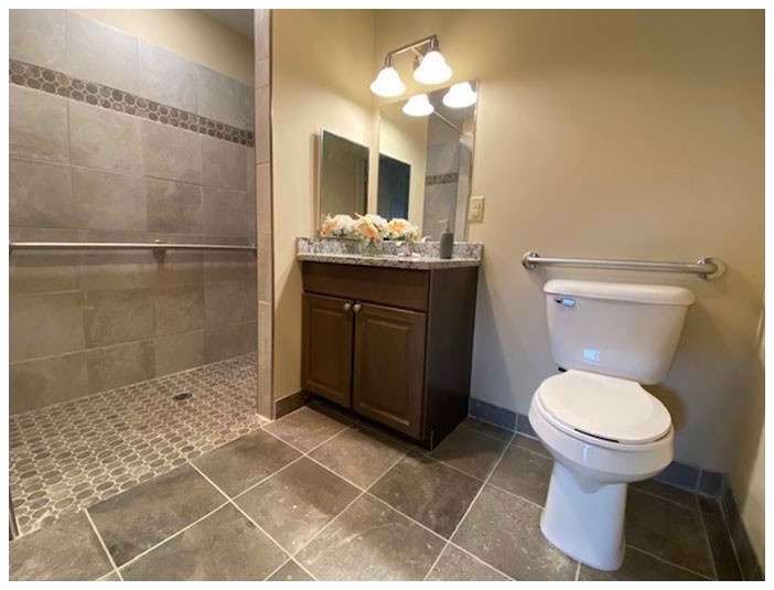 A modern bathroom with a tiled shower and vanity area.