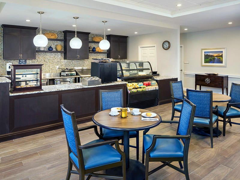 A modern cafe interior with a seating area and service counter.