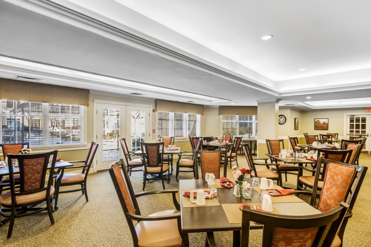 A well-lit dining area with neatly arranged tables and chairs.