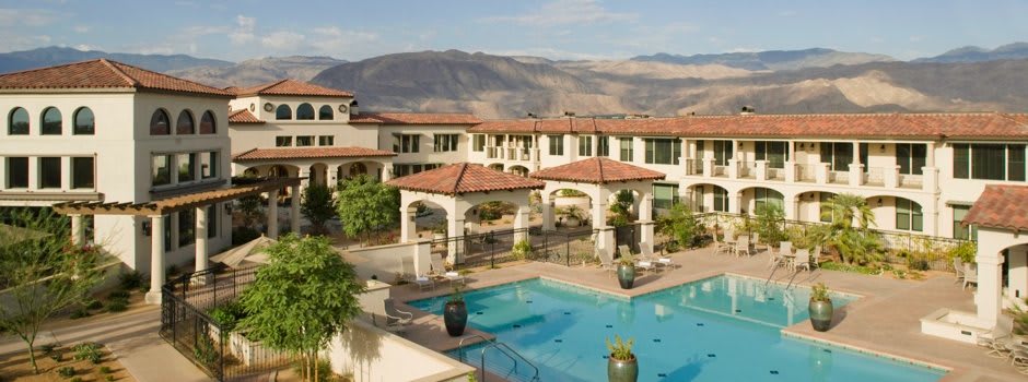 A scenic view of a resort with a swimming pool and mountainous backdrop.