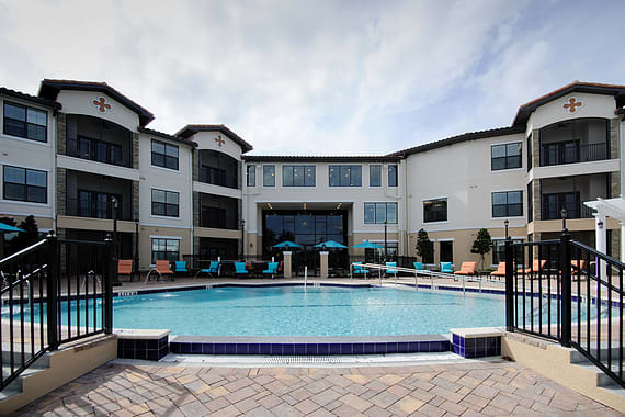A modern apartment complex with an outdoor swimming pool.