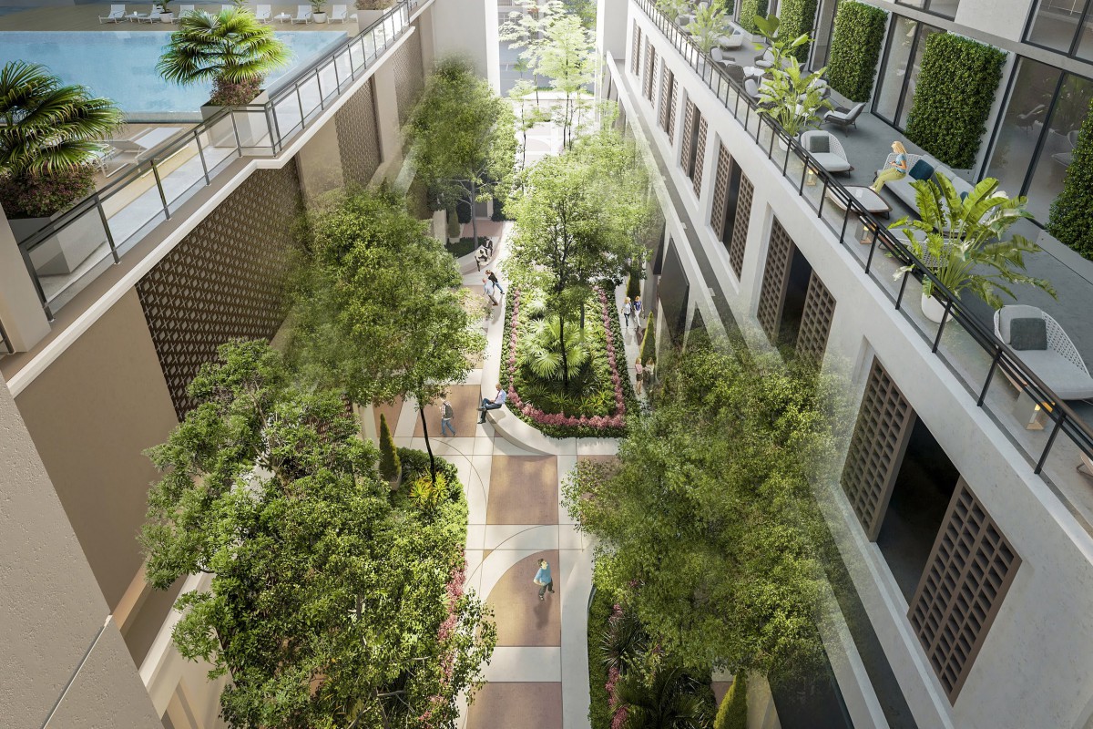 A modern urban courtyard surrounded by buildings, featuring lush greenery and a paved pathway.