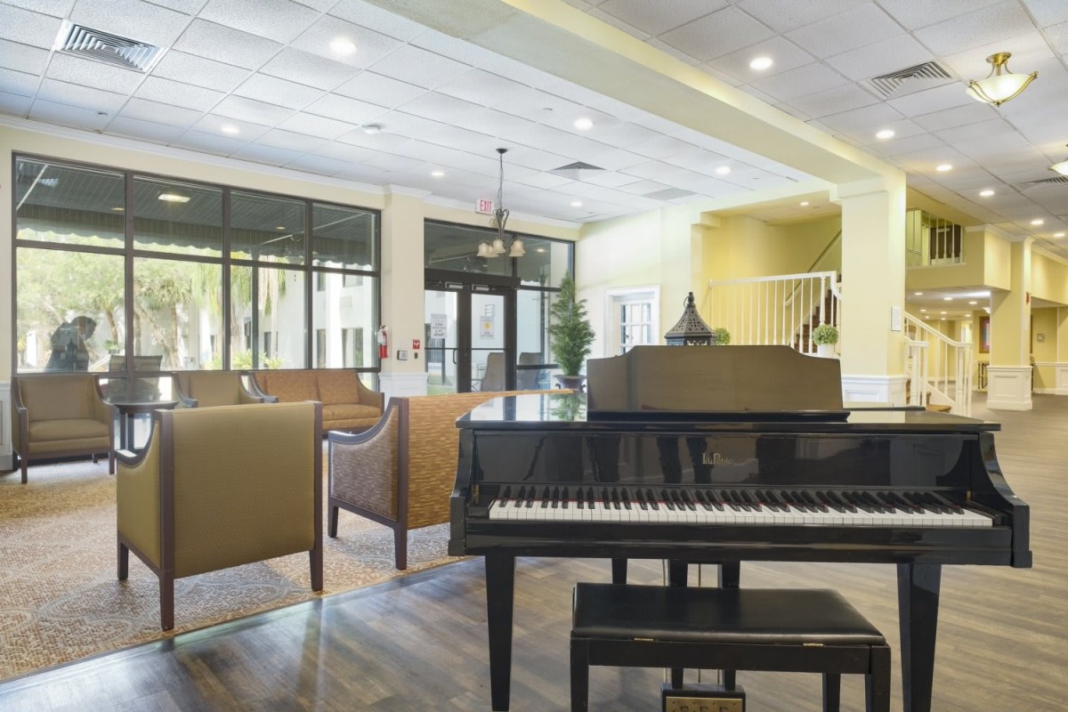 A modern lobby featuring a grand piano and comfortable seating.